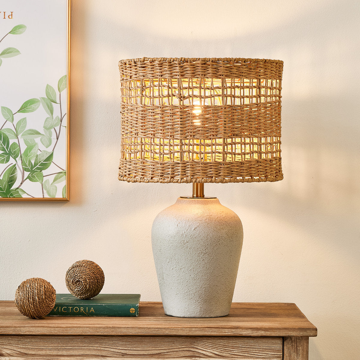 Gray Ceramic Table Lamp with Woven Rattan Shade — lit on a console
