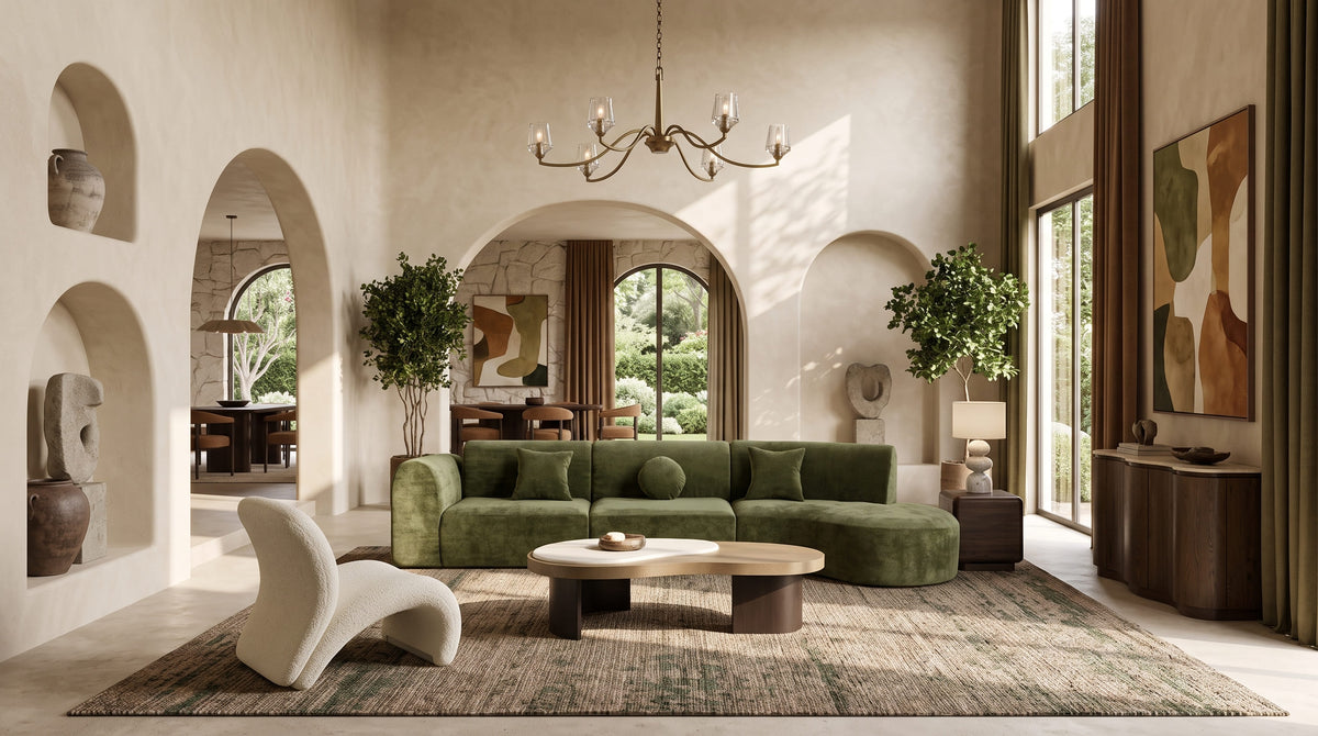 OROA living room featuring a curved sofa in a richly layered organic modern interior with warm wood, natural stone, sculptural lighting, earthy accents, high ceilings, large windows, and an open-plan connection to adjoining spaces.