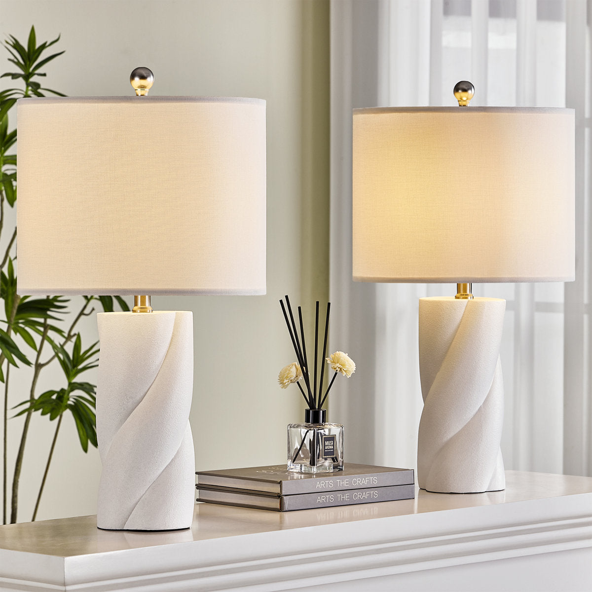 White Sculpted Ceramic Table Lamps — lit pair on a console