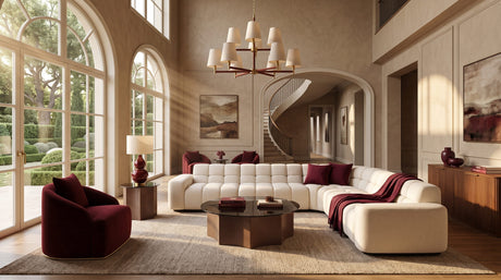 Living room featuring a deep burgundy accent chair, walnut furniture, cream upholstery and warm brass details, styled in a refined Fall 2026 palette by OROA.