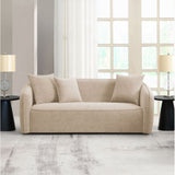 Beige sofa in a modern living room with large windows and side tables.
