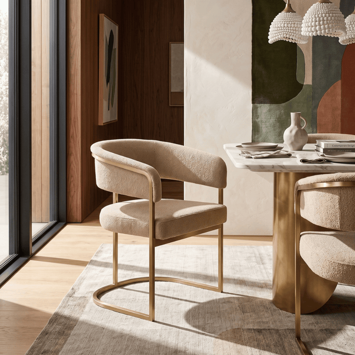 An OROA dining chair anchors a warm minimalism dining room, pairing refined upholstery with warm wood, natural textures, and contemporary architectural details.
