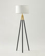 Floor lamp with black tripod base and white shade on a light gray background