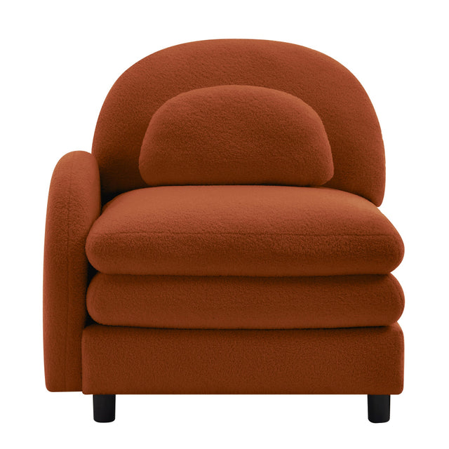 A modern low-profile armchair upholstered in a textured, bouclé-like fabric in a warm rust-orange color, featuring a rounded backrest, a matching back cushion, and thick seat cushions, supported by small black legs, shown against a plain white background.