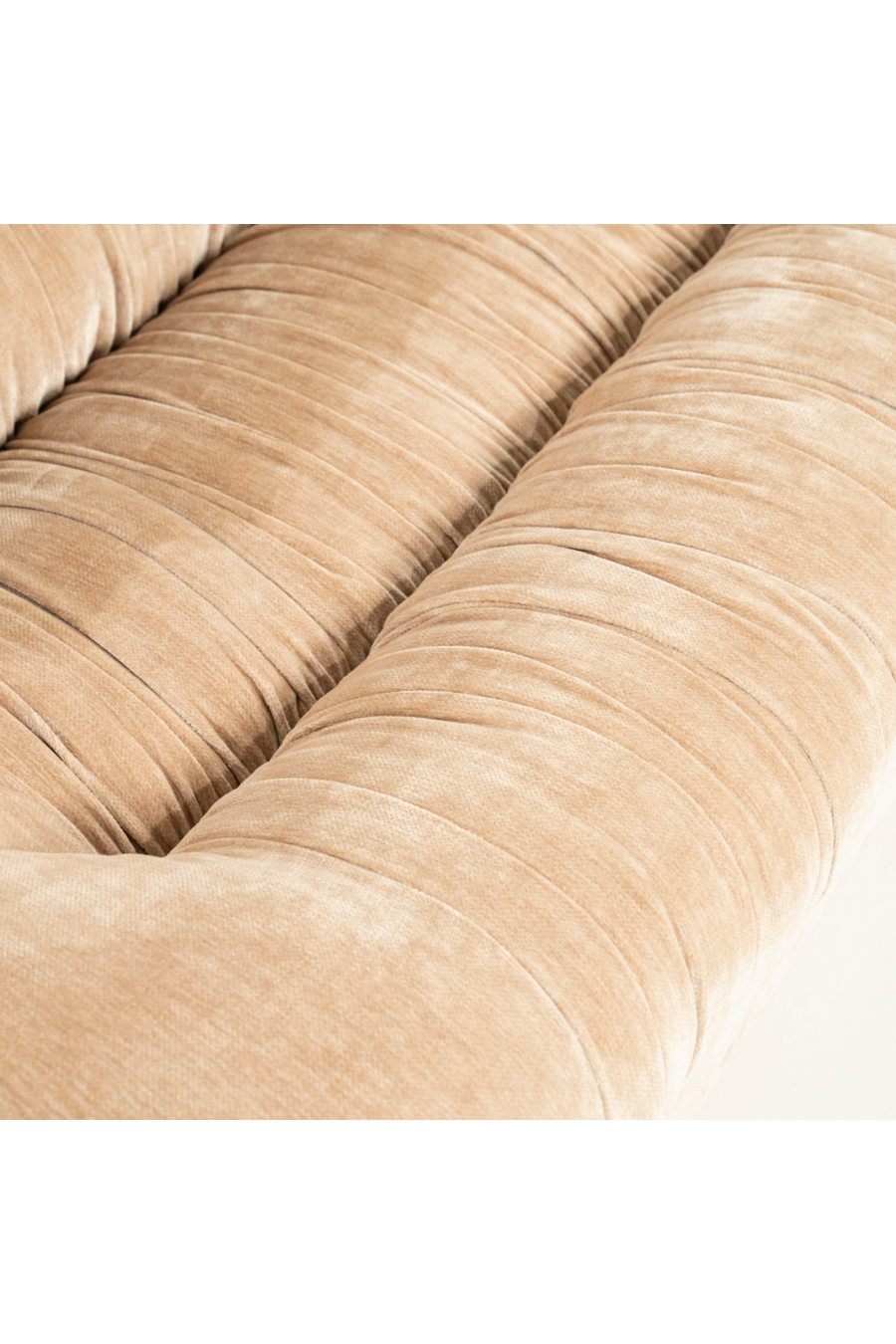 Close-up of tufted seam lines on beige sofa