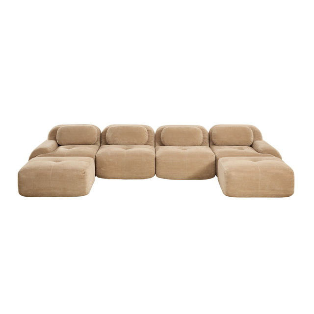 A modular tufted sectional sofa in a warm beige fabric, featuring four back cushions and two matching ottomans, shown against a plain white background.