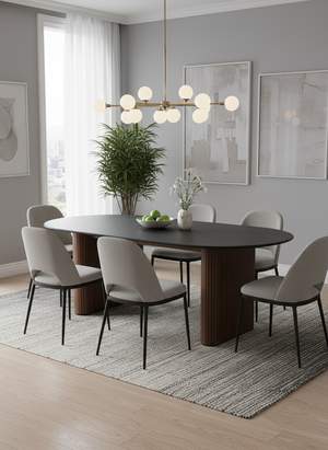 Dining room with a round wooden table and gray chairs, featuring a modern chandelier and decor.