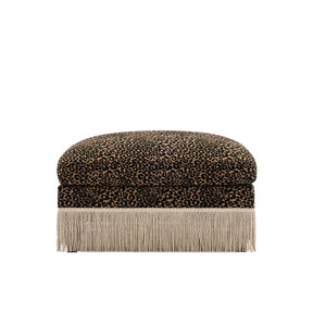 A square ottoman with a leopard print velvet top and a long fringe base, shown against a plain white background.