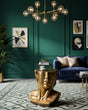 A decorative gold bust-shaped side table with a sculpted human face.