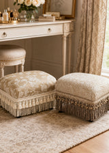 upholstered ottomans with floral damask fabric and fringe trim