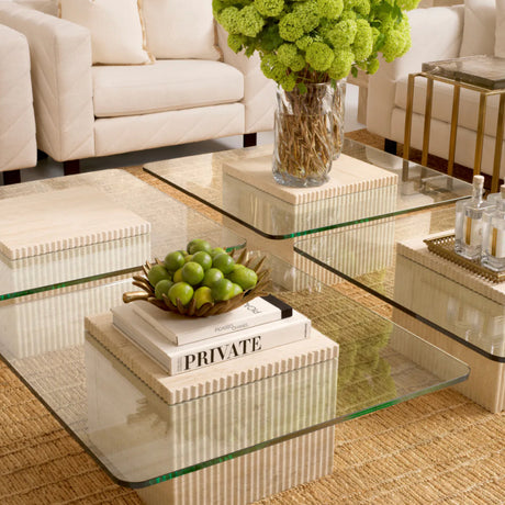 Glass coffee table with decorative items in a living room setting